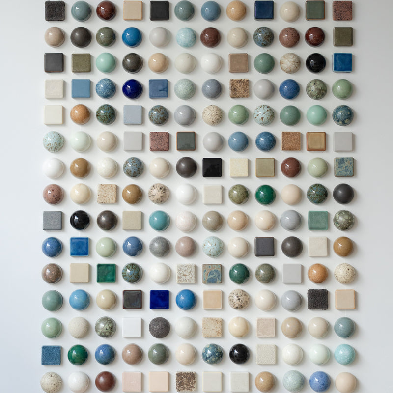 A wall of handmade ceramic domes and checkers in layered glazes